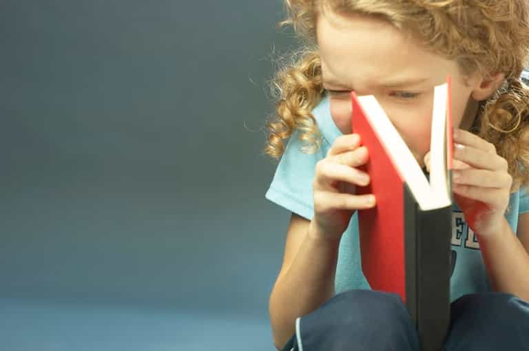 A young girl is told to stop reading on the school bus because it’s dangerous